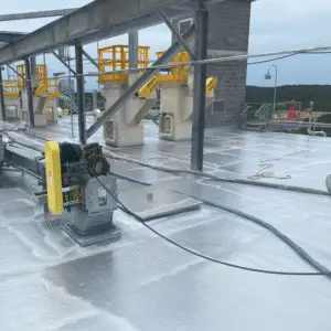 Industrial rooftop or flooring surface coated with a high-performance polymer protective coating