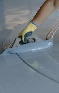 Close-up of a trowel applying a smooth epoxy or resinous flooring coating