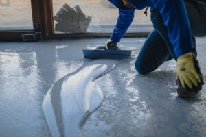 A person applying epoxy flooring for his business