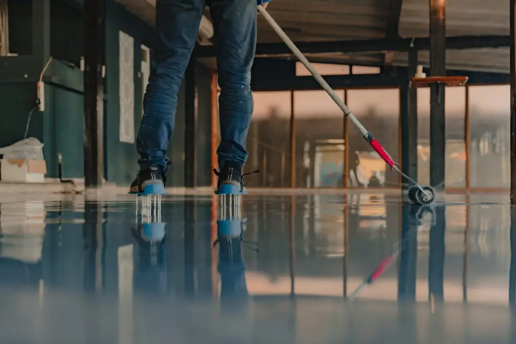 The worker applies epoxy resin to the new floor