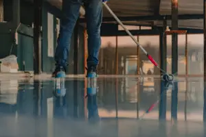 The worker applies epoxy resin to the new floor