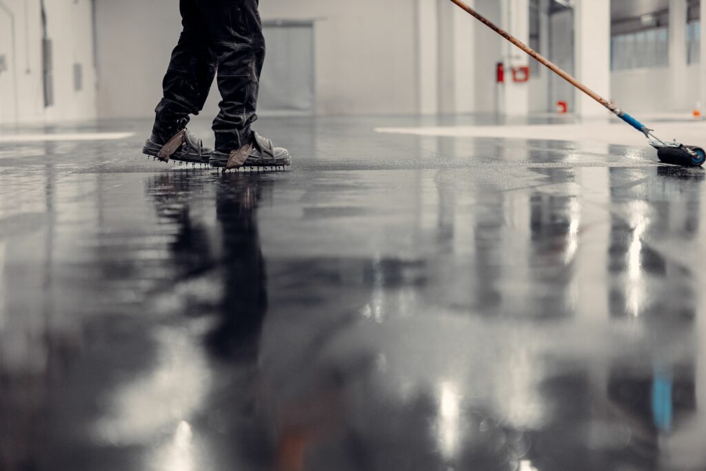 A worker applying epoxy flooring with the right epoxy systems